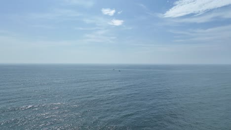 fishing boat anchored in heart of blue ocean in sunny day, lima, peru