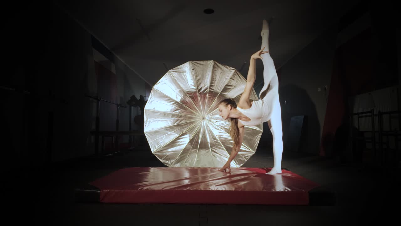 Gymnast performing acrobatic split in gym