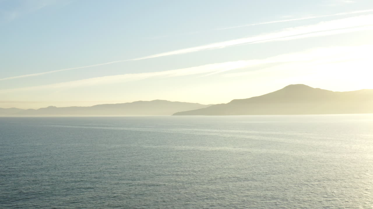 수평선에 있는 바다와 산 너머로 아름다운 공중 무인 항공기 전망 일몰
