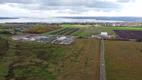 Aerial-view-of-farm-land-and-lake-on-the-edge-of-Northern-Ontario,-Canada-town