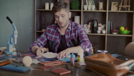 Leather-maker-throwing-leather-on-table.-Angry-craftsman-working-in-workshop