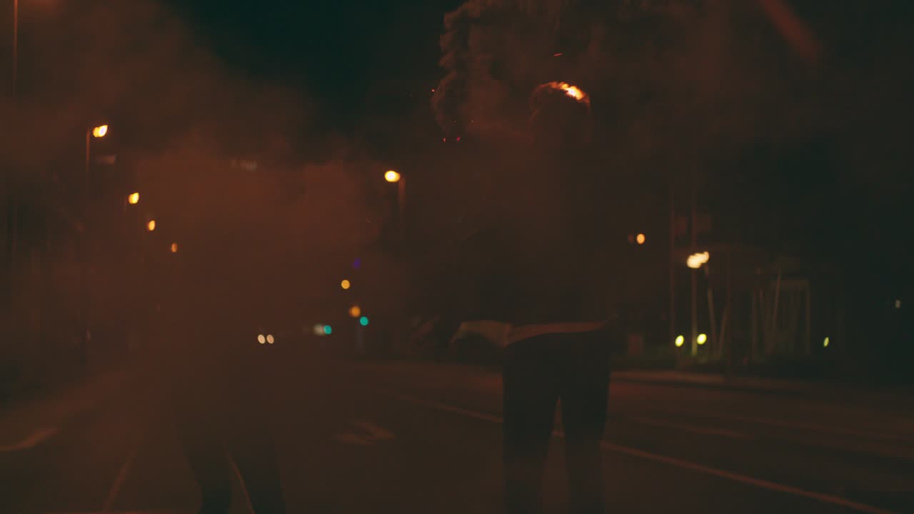 십대 들 이 밤 에 연기 불 을 들고 도시 거리 를 달리고 있다