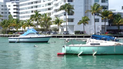 Dos-Botes-Pequeños-Estacionados-Frente-A-Un-Hermoso-Rascacielos-En-Miami-Beach,-Florida