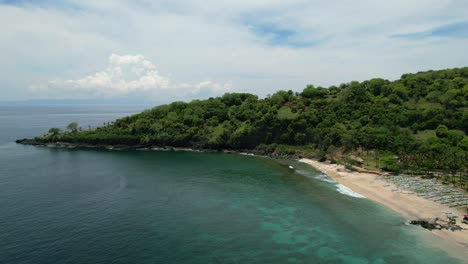empty white sand beach in east bali at pantai prasi on sunny day with turquoise ocean, aerial