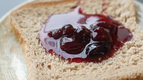 spreading jam on on slice bread