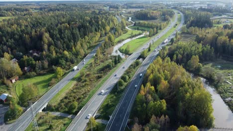 aerial: vehicle traffic drives on highway in northern city in finland