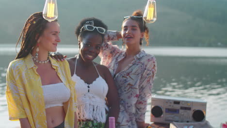 portrait of beautiful female friends on lake party