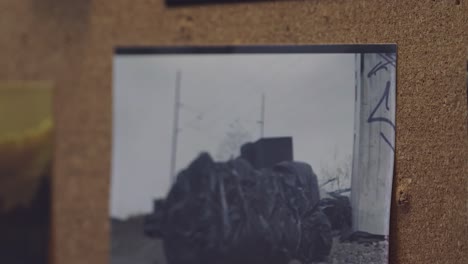 a detective's hands organize crime scene photos on an evidence board