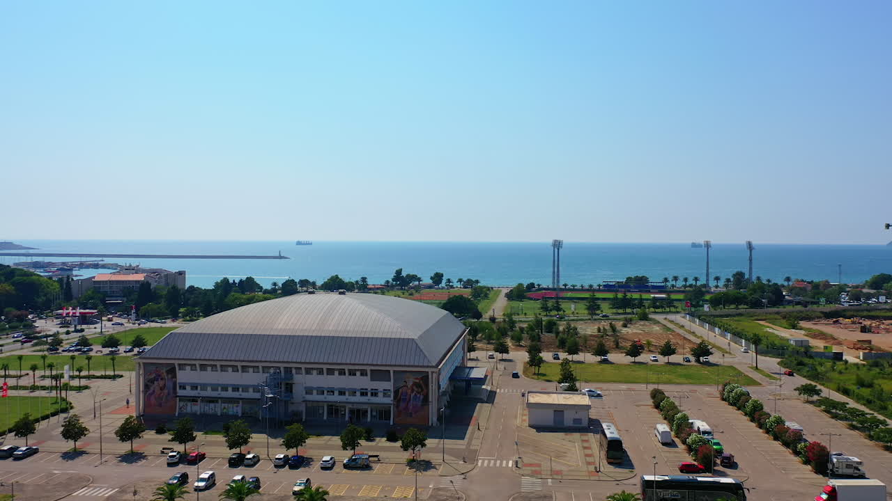 Beautiful open area with parks and stadiums at the shore of Adriatic Sea. Bar, Montenegro at the seashore from top.