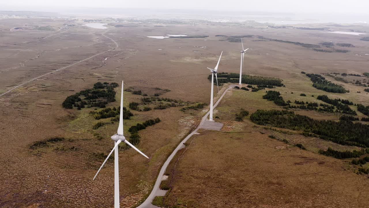 дрон, кружащий вокруг ветряной электростанции, работающей при сильном ветре на гебридах