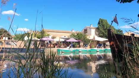 canal bank with barges and cafe on the canal du midi france