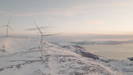 wind turbine producing renewable energy in fjord landscape, aerial