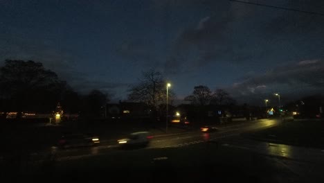 gloomy evening storm clouds and vehicle headlights passing across british road junction time lapse