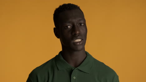 un hombre afroamericano disgustado sobre un fondo amarillo.