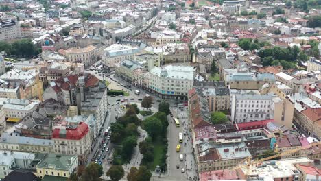 Parque-En-El-Centro-De-Lviv,-Ucrania,-Con-Vistas-A-Los-Antiguos-Edificios-Históricos-De-La-Ciudad-Europea-Con-Coches-Circulando-Por-La-Carretera-Y-El-Horizonte-En-El-Fondo