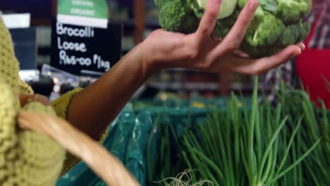 Smiling-male-staff-assisting-a-woman-with-grocery-shopping