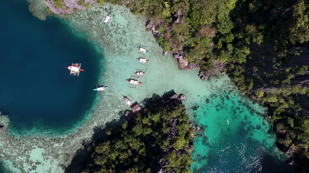 Drone view of Philippines, Coron Island’s untouched coastline, surrounded by clear ocean waters. Aerial view of boats Vertical video.