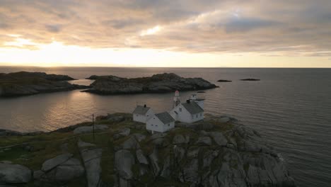 Sunset-view-of-the-Henningsvaer-lighthouse-in-Lofoten,-Norway-on-rocky-coastline