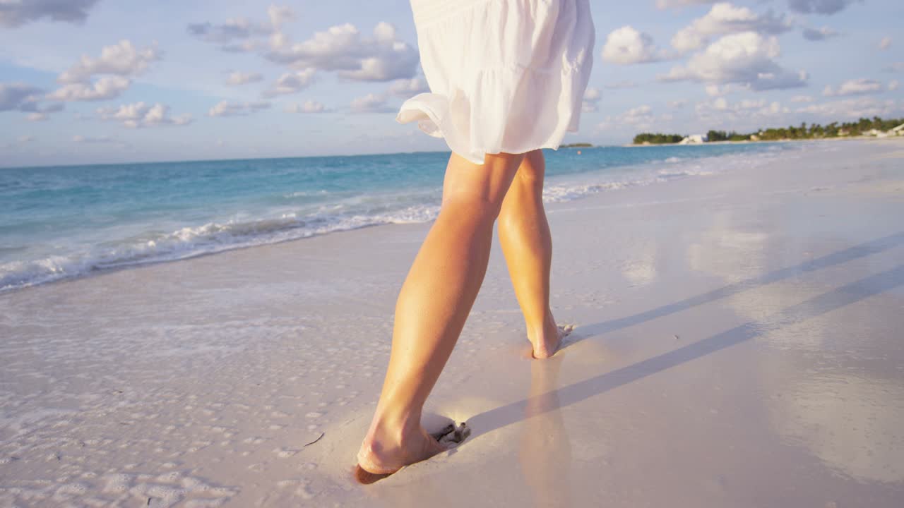 Gambe di donna caucasica a piedi nudi che si gode il tramonto sull'isola.