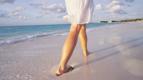 legs of barefoot caucasian female enjoying island sunset