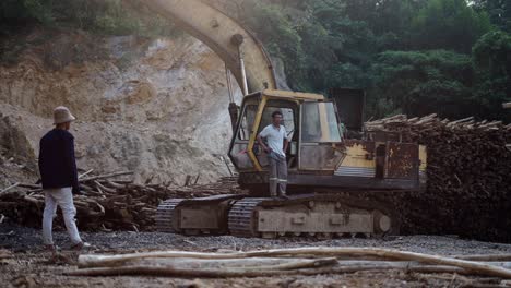 excavator and workers at a logging site