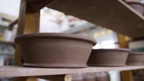 Group-Of-Handmade-Clay-Bowls-On-Shelves-Of-Ceramics-Studio