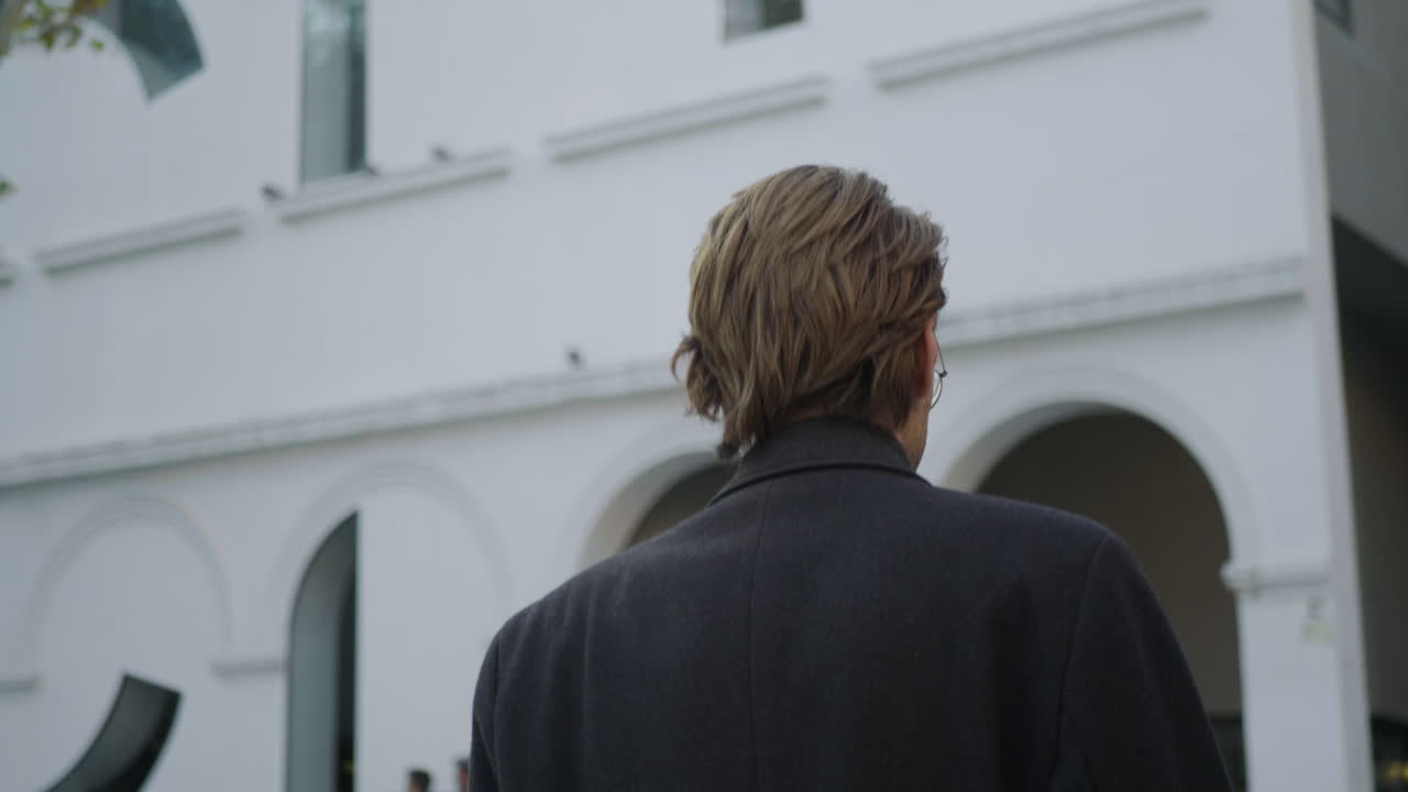 도시 거리에서  ⁇ 고 있는 젊은 사업가. 야외 회의를 위해 가는 임원