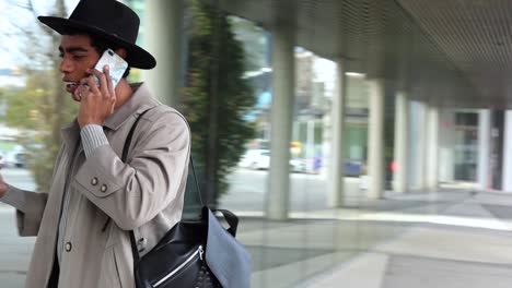 stylish ethnic man speaking on smartphone on the street