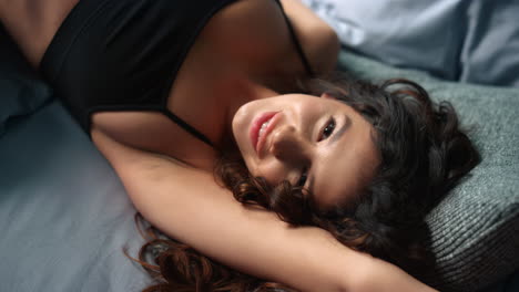 attractive woman lying on soft pillows on bed