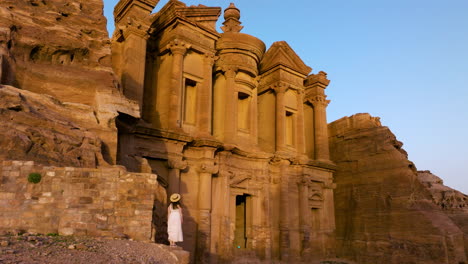 Frau-Im-Kleid-Steht-Und-Bewundert-Die-Schönheit-Des-Klosters-Ad-Deir-In-Petra,-Jordanien