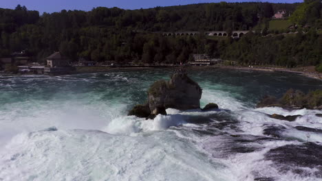 Slow-Motion:-Static-shot-of-a-large-rock-sitting-in-a-roaring-waterfall