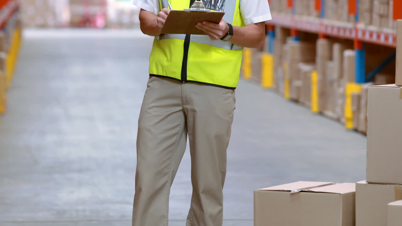 trabajador de almacén masculino escribiendo en el clipboard