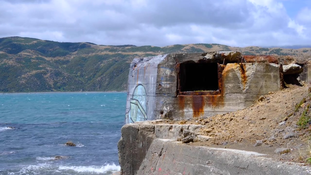 Forladt bunker med graffiti langs havkystlinjen ved indsejlingen til Wellington havn i Wellington, New Zealand Aotearoa