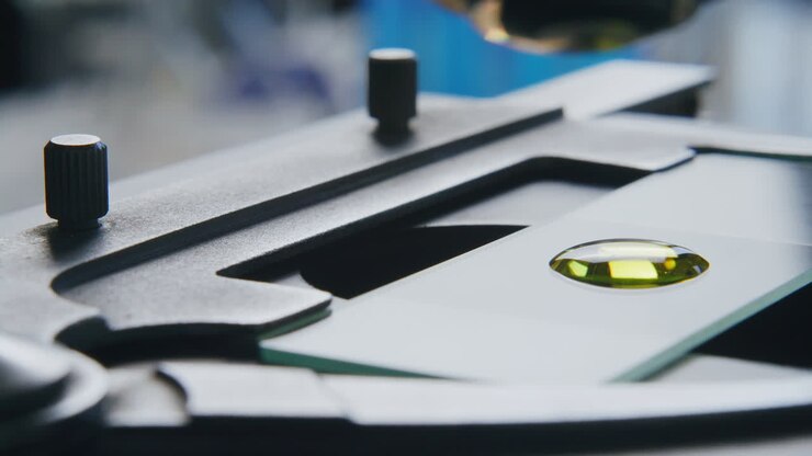 Primo piano di un campione di liquido giallo esaminato al microscopio