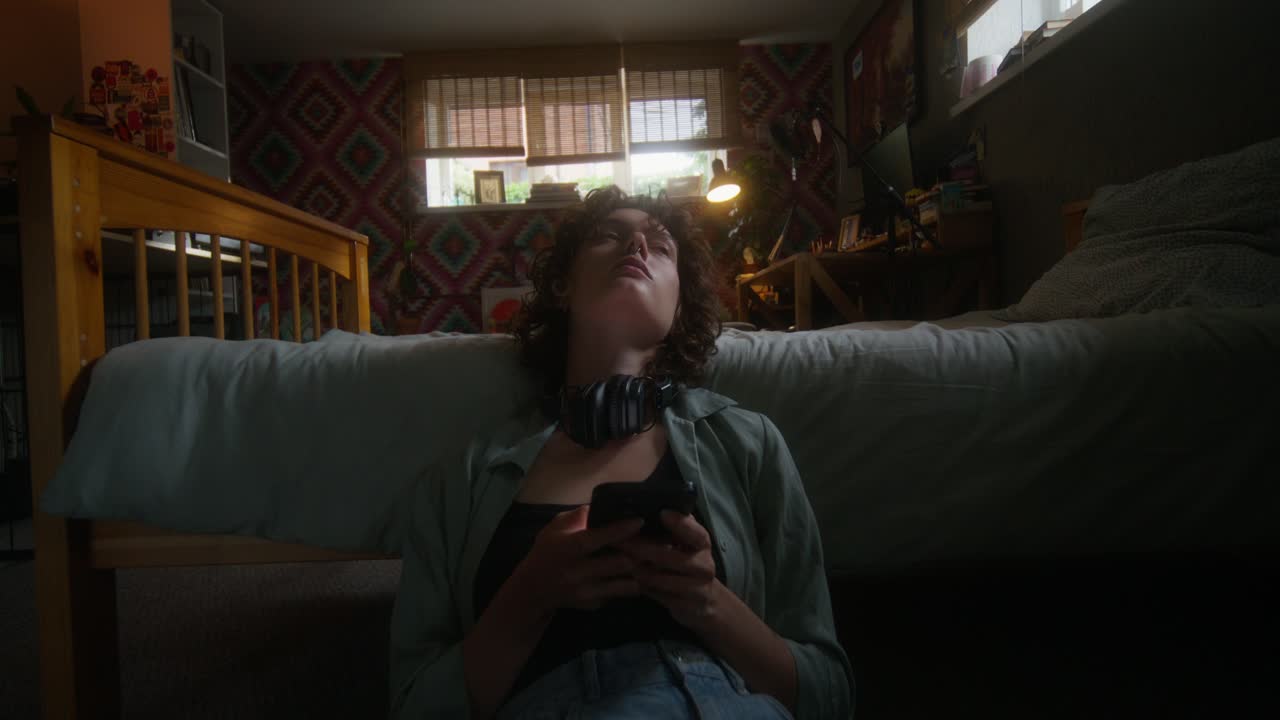 joven usando el teléfono en el dormitorio