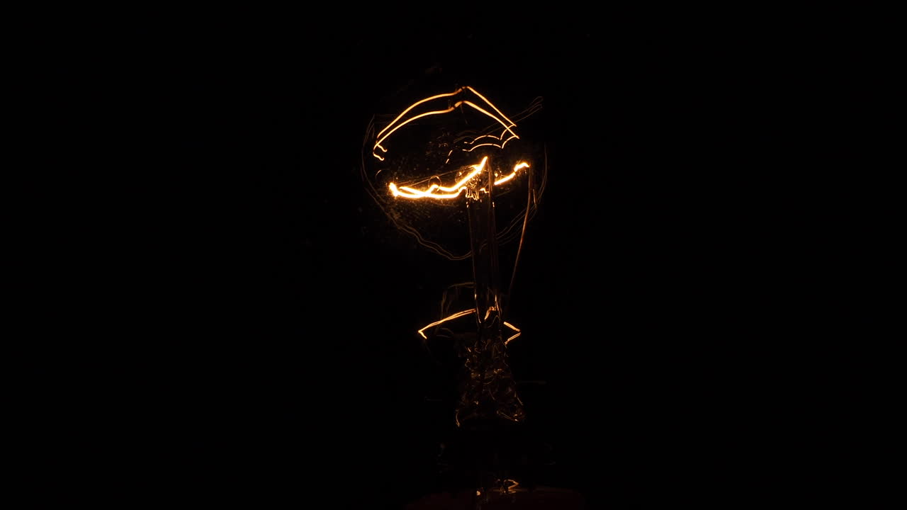 Primo piano di una lampadina che si accende e si spegne, sfarfallando, in tempo reale