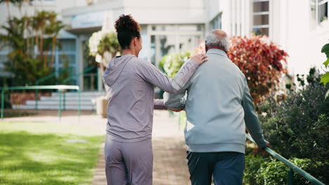 Caregiver assisting senior man walking outside