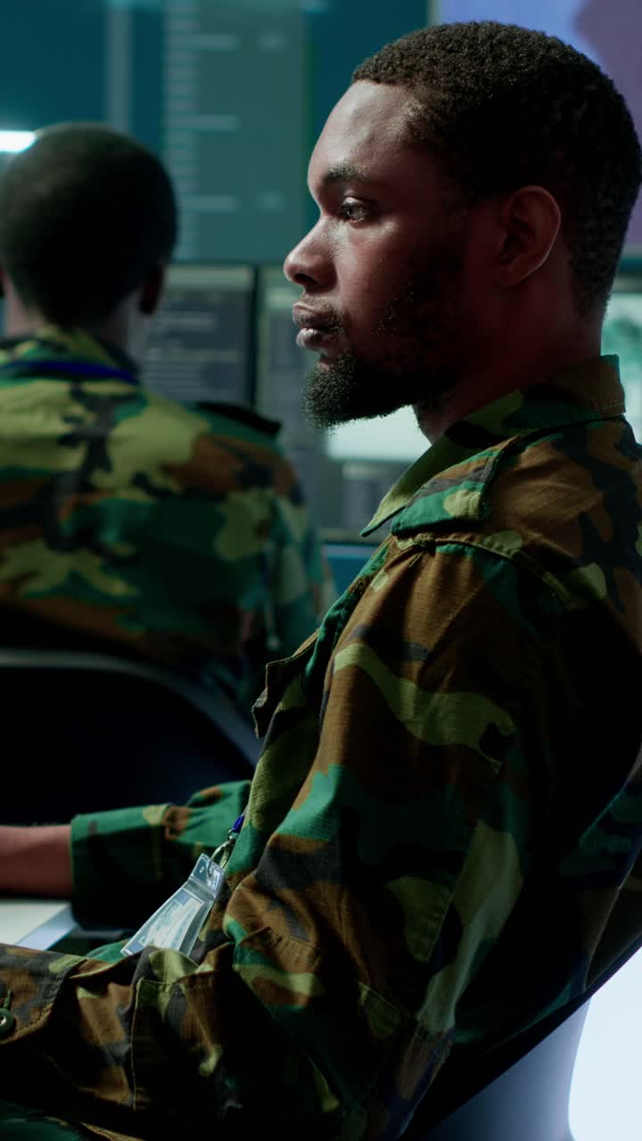 Video verticale: Personale militare in un centro di comando ad alta tecnologia che monitora i feed satellitari.