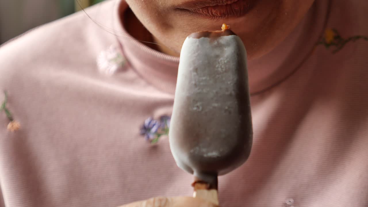una mujer comiendo un helado de chocolate.