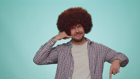 Cheerful-one-man-in-shirt-looking-at-camera-doing-phone-gesture-like-says-hey-you-call-me-back