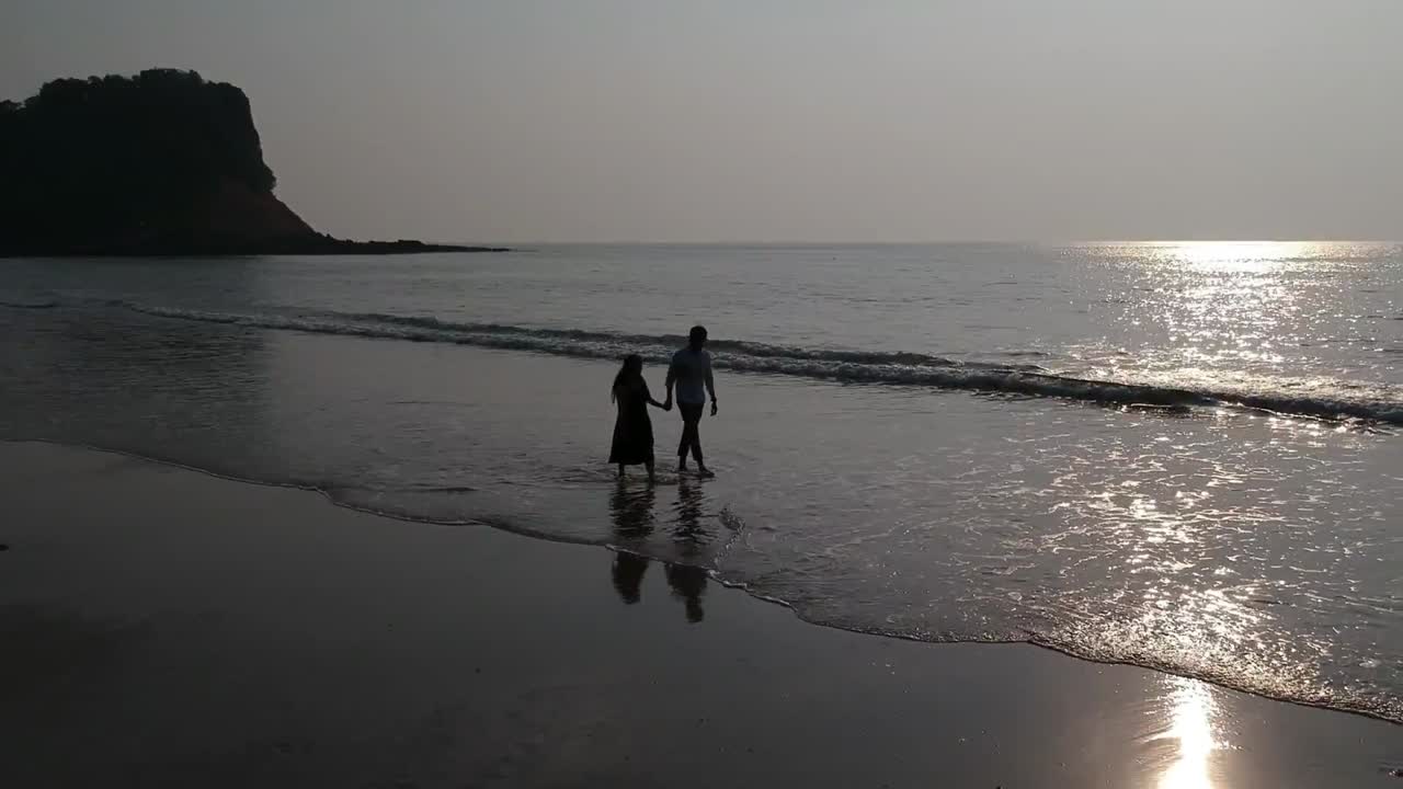 해변에서 걷는 커플 - 공중 드론 비디오
