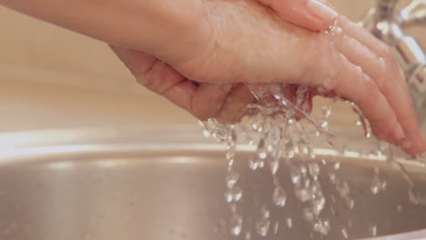 woman washing her hands in a sink