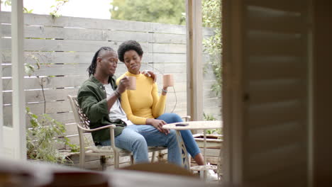 relaxing on patio, african american couple enjoying coffee and spending quality time together