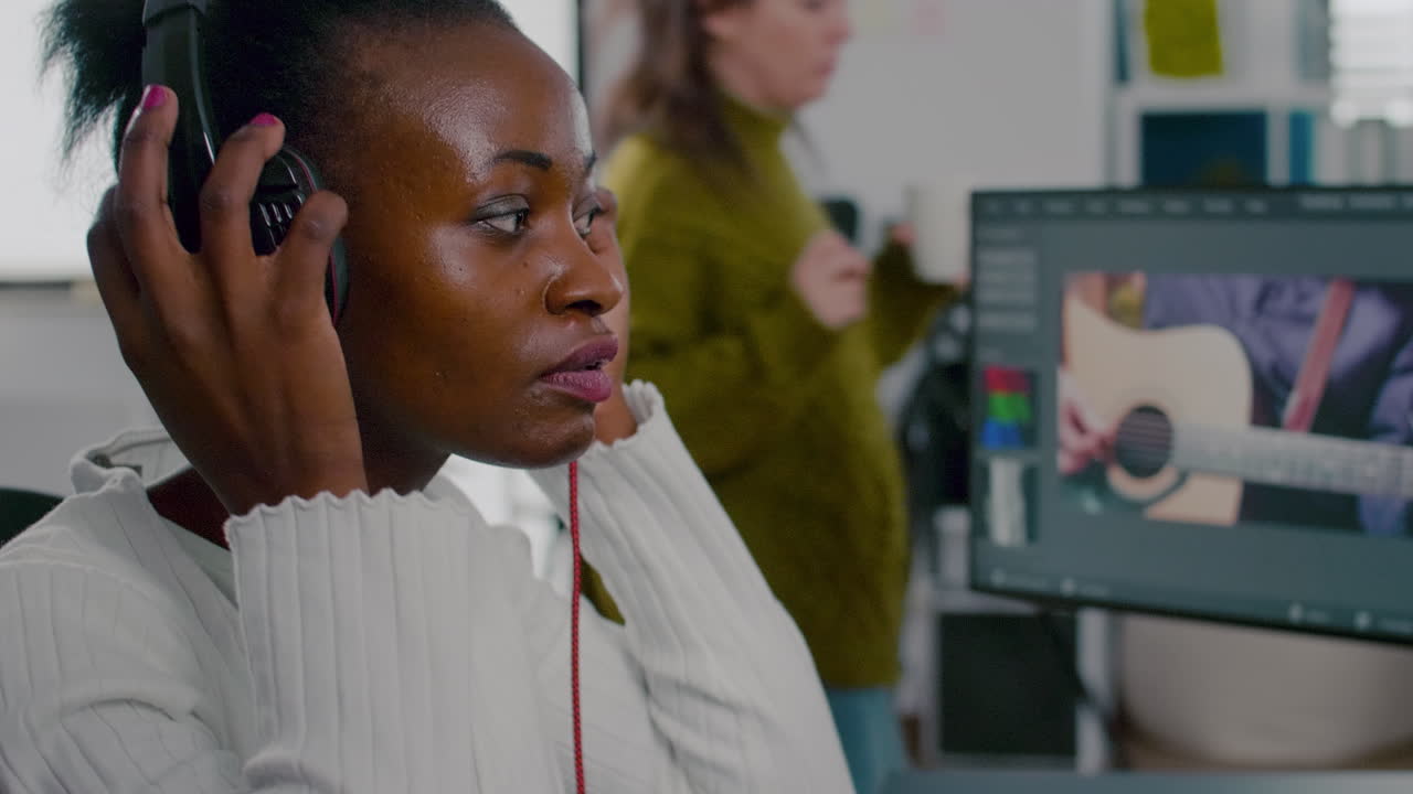 검은색 비디오 편집자는 두 개의 모니터를 가진 pc에서 영상으로 작업합니다.