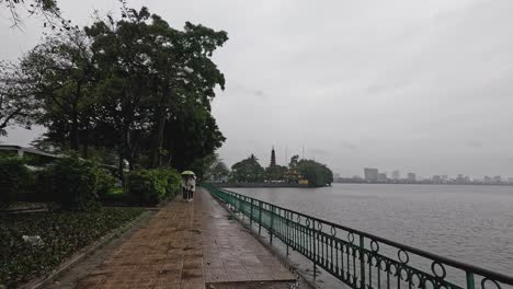 person walking by a lake on a rainy day