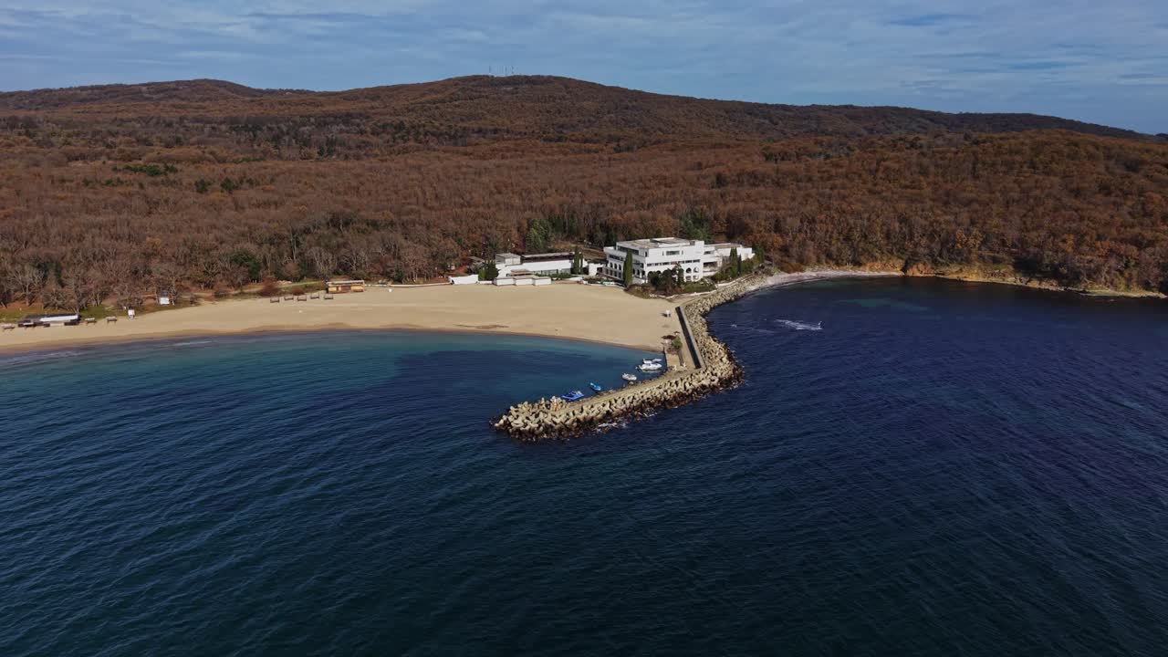 Scenic aerial view of beachfront property near forested mountains