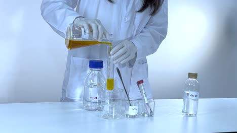 scientist conducts potassium carbonate experiment, pouring liquid into beaker. controlled laboratory environment with bright lighting