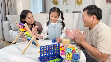 a family engages in educational math activities using an abacus and dice, fostering learning and togetherness in a cozy living room