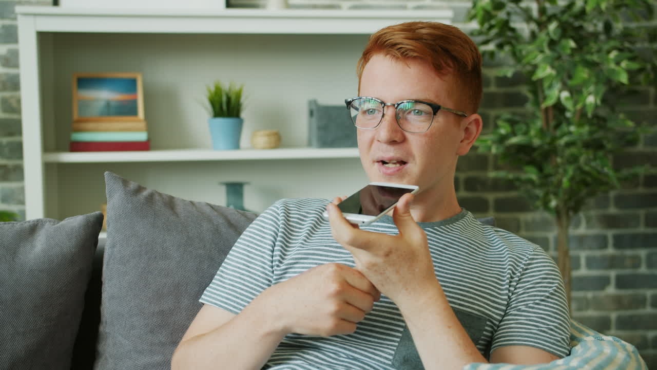 Giovane che per mezzo dello smartphone a casa