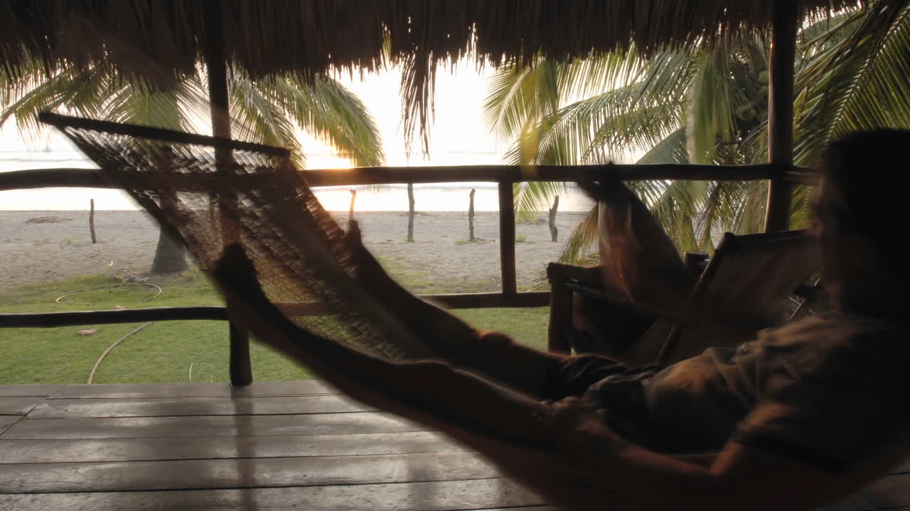 lapso de tiempo del hombre sentado en una hamaca en palapa en la playa la saladita guerrero mexico